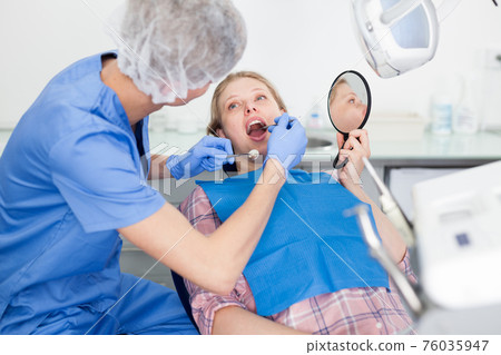Young woman on dental checkup in modern dentist office Young woman on dental checkup in modern dentist office 76035947