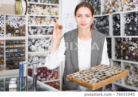 Female seller showing buttons 76035948