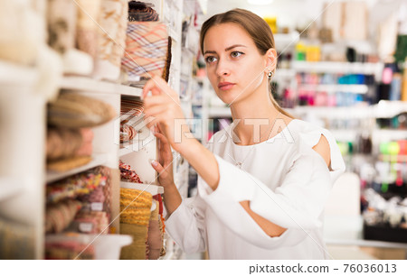 Girl choosing ribbons for needlecraft Girl choosing ribbons for needlecraft 76036013