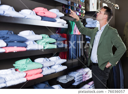 Guy deciding on new tie 76036057