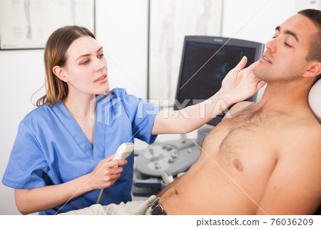 Woman sonographer examining male patient Woman sonographer examining male patient 76036209