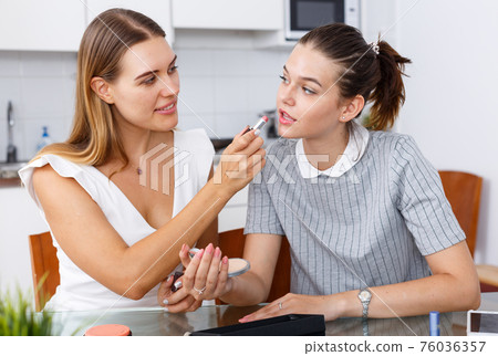 Two girls applying make up Two girls applying make up 76036357