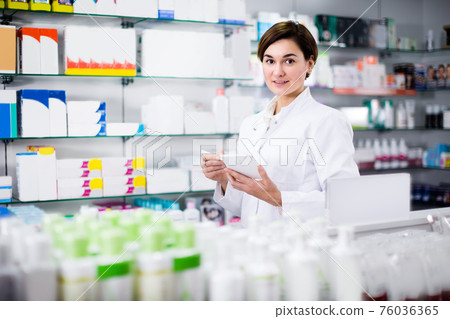 Young female is writing down assortment of drugs 76036365