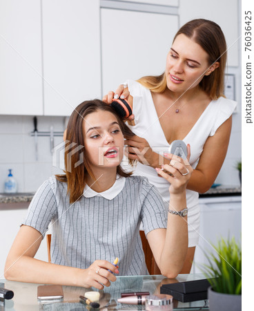 Two girls applying make up Two girls applying make up 76036425