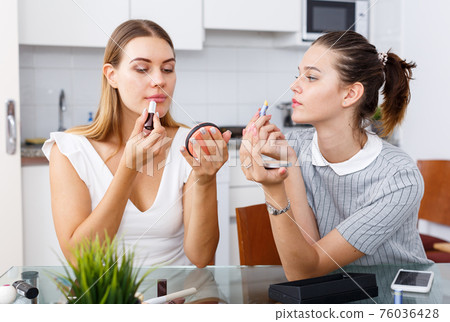 Two girls applying make up Two girls applying make up 76036428