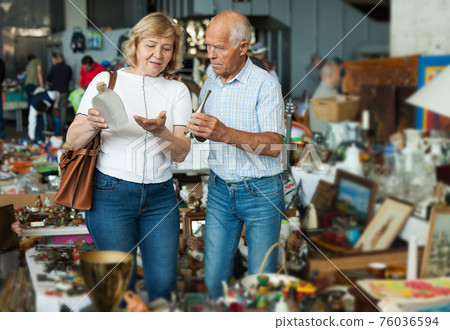 Elderly couple in flea market chooses antique items Elderly couple in flea market chooses antique items 76036594