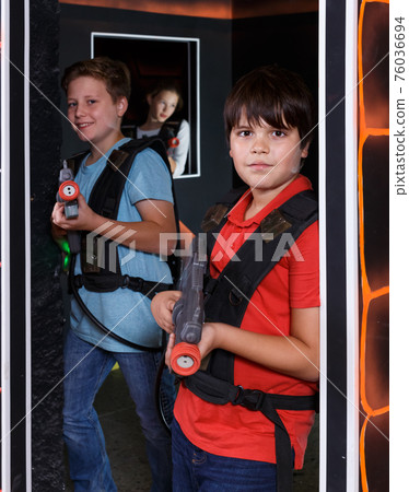 Two jolly teen boys standing with laser guns Two jolly teen boys standing with laser guns 76036694