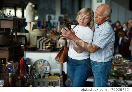 Elderly family choose handmade vase at flea market 76036723