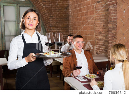 professional woman waiter demonstrating restaurant to visitors professional woman waiter demonstrating restaurant to visitors 76036842