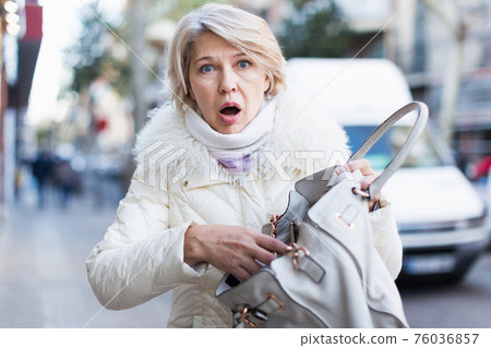 Upset female in the city with empty bag lose phone Upset female in the city with empty bag lose phone 76036857