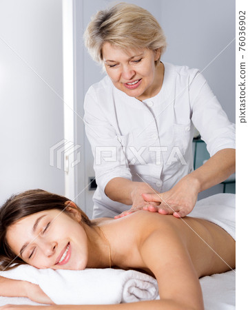Girl having professional massage in spa salon 76036902