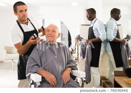 Gray-haired man discussing haircut with barber Gray-haired man discussing haircut with barber 76036948