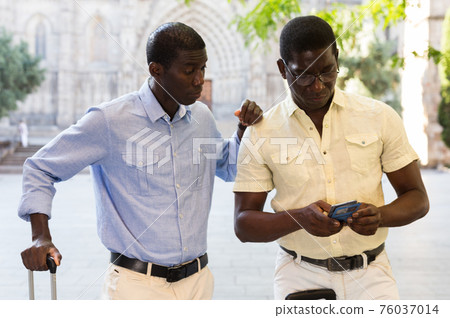 African american tourists use phone to navigate an unfamiliar city 76037014