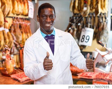 Butcher shop owner giving thumbs up Butcher shop owner giving thumbs up 76037035