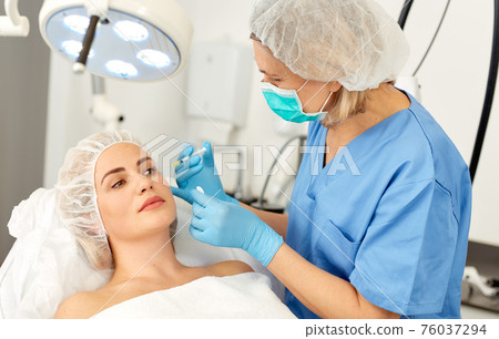 Portrait of woman during beauty facial injections in medical esthetic office Portrait of woman during beauty facial injections in medical esthetic office 76037294