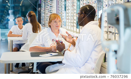 African American ophthalmologist consulting elderly woman African American ophthalmologist consulting elderly woman 76037296