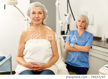 Smiling mature female patient satisfied with received cosmetological procedure in esthetic clinic Smiling mature female patient satisfied with received cosmetological procedure in esthetic clinic 76037297