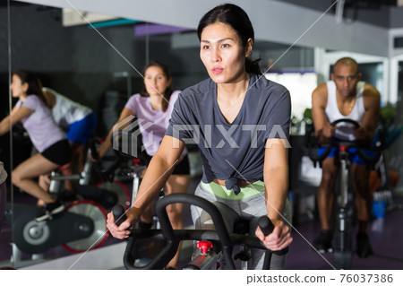 Woman and other females working out in club Woman and other females working out in club 76037386