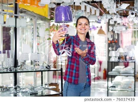 Girl proposes to look a bright lamp Girl proposes to look a bright lamp 76037439
