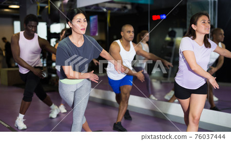 Group of people practicing together in gym 76037444
