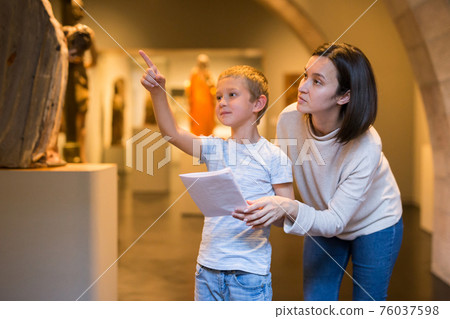 Woman and boy observing sculptures exhibition 76037598