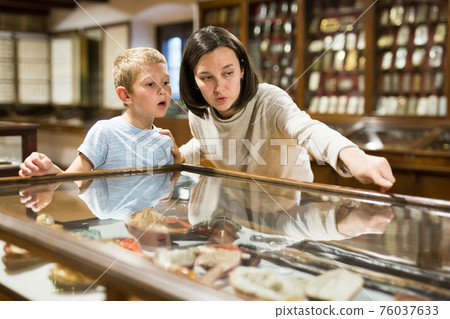 Woman and boy exploring artworks in museum 76037633