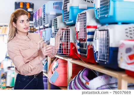 Attractive girl buying portable carrier for pet Attractive girl buying portable carrier for pet 76037669