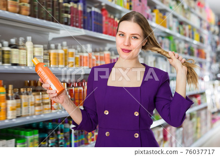 Satisfied woman demonstrating her healthy hair 76037717