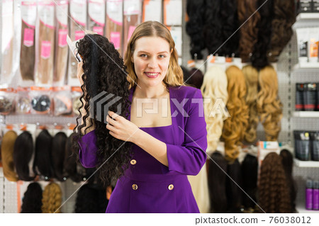 Girl choosing wigs from natural hair Girl choosing wigs from natural hair 76038012