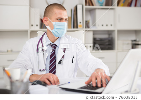 Positive professional doctor man in protective mask Positive professional doctor man in protective mask 76038013
