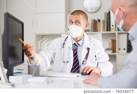 doctor in protective mask advising a patient doctor in protective mask advising a patient 76038077