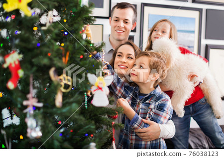 Family decorating Christmas tree at home Family decorating Christmas tree at home 76038123