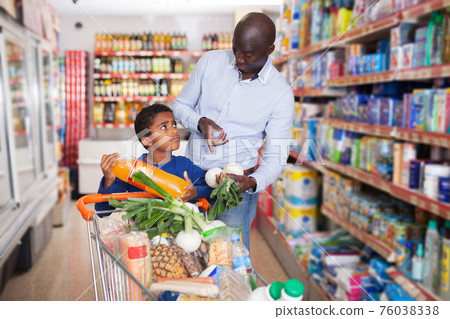 man with son choosing fresh greens and vegetables man with son choosing fresh greens and vegetables 76038338