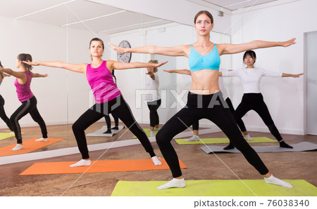 Women doing stretching exercises for yoga in the room Women doing stretching exercises for yoga in the room 76038340