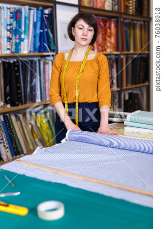 Woman seller of tissue store near cutting table Woman seller of tissue store near cutting table 76038918