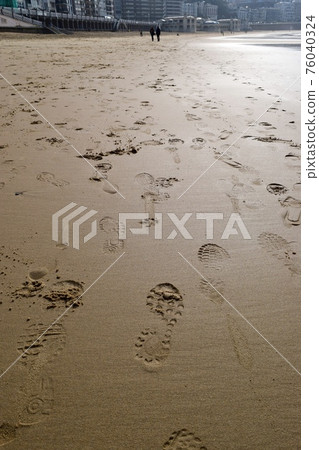 Footprints of shoes on the sandy beach 76040324