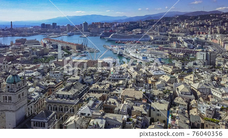 Aerial panoramic drone view of buildings and streets surrounding Port of Genoa.Cruise ship in port. 76040356