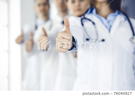 Group of modern doctors standing as a team with thumbs up in hospital office. Medical help, insurance in health care, best desease treatment and medicine concept 76040927