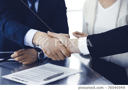Business people shaking hands after contract signing in modern office. Teamwork, partnership and handshake concept 76040949