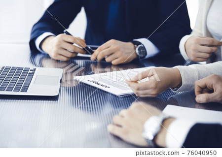 Business people discussing contract working together at meeting in modern office. Unknown businessman and woman with colleagues or lawyers at negotiation Business people discussing contract working together at meeting in modern office. Unknown businessman and woman with colleagues or lawyers at negotiation 76040950