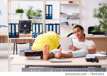 Young male employee looking after newborn at workplace 76041662