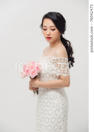Fashion portrait of elegant woman with rose flower bouquet over white background. Fashion portrait of elegant woman with rose flower bouquet over white background. 76042473