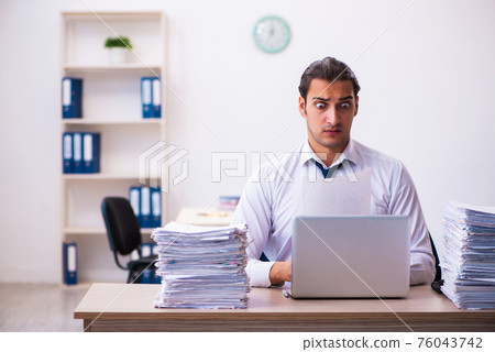 Young male employee unhappy with excessive work 76043742