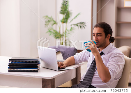 Young male employee working from home during pandemic 76043755