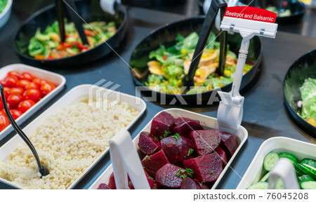 Salad bar buffet at restaurant. Fresh salad bar buffet for lunch or dinner. Healthy food. Beetroot and balsamic in bowl on counter. Catering food. Vegetarian food. Healthy eating. Plant-based diet. 76045208