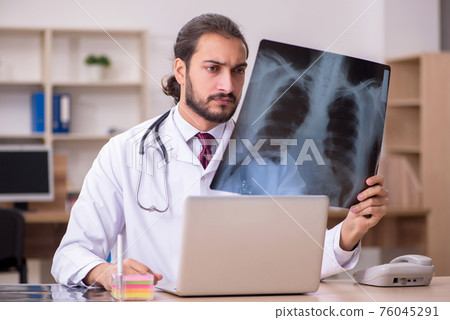 Young male doctor radiologist sitting in the office 76045291