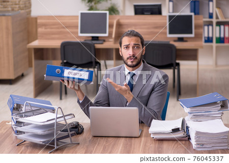 Young businessman employee unhappy with excessive work in the of 76045337