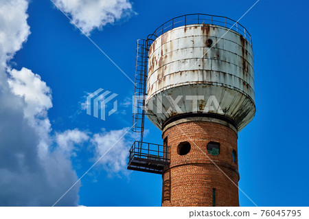 Water tower made of brick and metal with round windows 76045795
