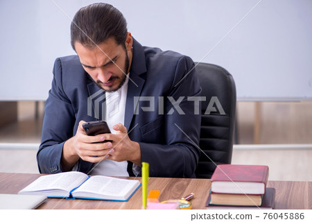 Young male teacher in the classroom Young male teacher in the classroom 76045886