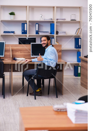 Young male employee working in the office Young male employee working in the office 76045900